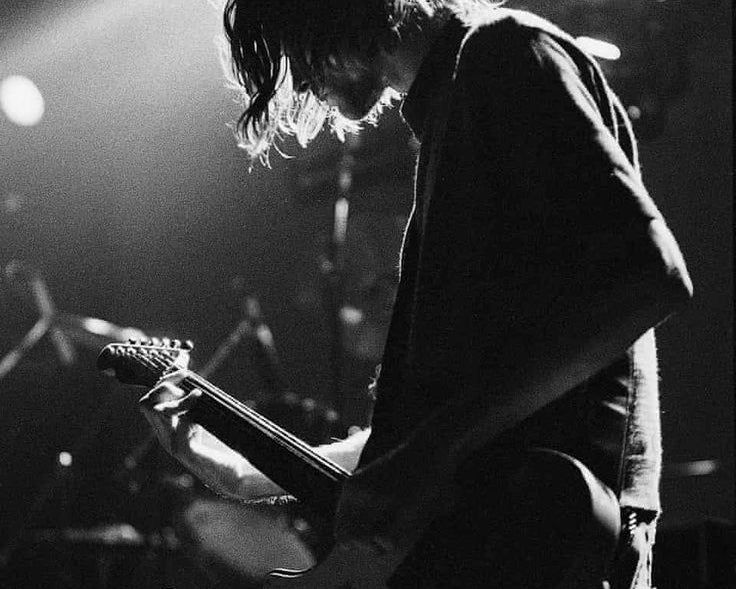 Person playing guitar on stage with a spotlight